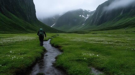 Fototapeta premium Hikers trail through misty alpine valley