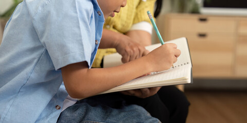 Mother and Son Back to School. A mother helps her son with homework, fostering a supportive...