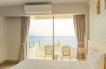 Bed and lamps in modern bedroom overlooking sea view