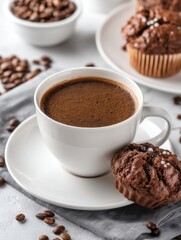 Obraz premium Rich dark coffee and chocolate muffin on a bright white table with coffee beans scattered around creating a cozy and inviting atmosphere for a delightful treat