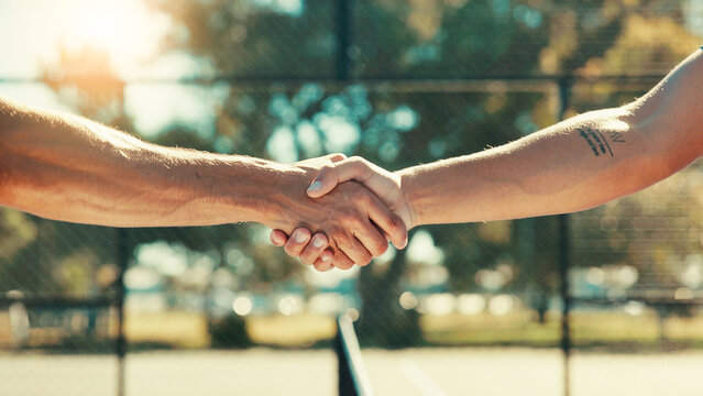 People, handshake and meeting with tennis court for sports competition, match or outdoor game. Closeup, team or shaking hands with net for start, sportsmanship or introduction together on playground