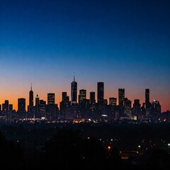 Fototapeta premium City skyline at dusk, silhouetted against a blue and orange sky. Lights twinkle from the buildings.