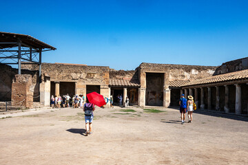 People, tourists walking among the excavations in the ancient Roman city of Pompeii, buried by the eruption of Vesuvius in 79 AD.