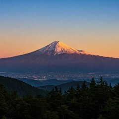 Fototapeta premium Majestic Mount Fuji capped with snow, glowing at sunset over a city and evergreen forest.