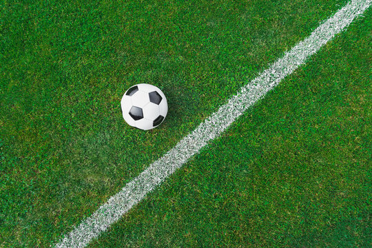 a soccer ball on the green grass on the line in soccer stadium.