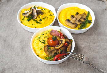Delicious dishes with corn porridge and grilled vegetables on a white background. Traditional...