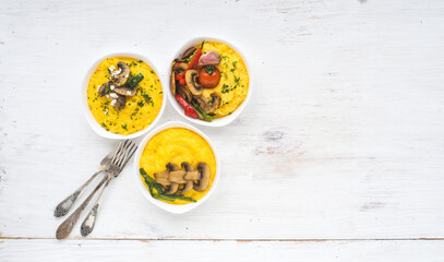 Set of dishes with corn porridge on a white background. Traditional Italian polenta without meat with different vegetables. Healthy food for every day.
