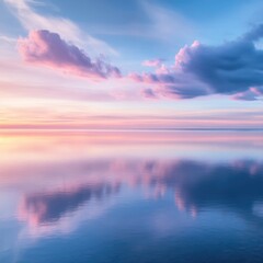 Obraz premium Serene seascape at dusk with pastel clouds reflecting in calm water creating a peaceful atmosphere and a sense of tranquility and vastness