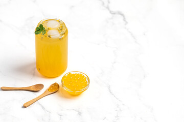 tropical Bubble Tea, Isolated on White Background. Colorful, Fresh Orange Boba Drink with Fruit Fizzy Jellies and Ice Cubes. Tapioca pearls. 