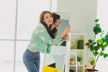Charming cheerful woman enjoying leisure time in a cozy home interior with spring fashion style
