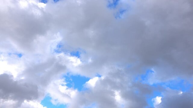 Vue en acc&eacute;l&eacute;r&eacute; sur des nuages blancs et gris dans un ciel bleu