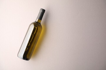 Bottle of wine on light grey background, top view. Space for text