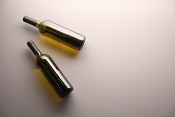 Bottles of wine on light grey background, flat lay. Space for text