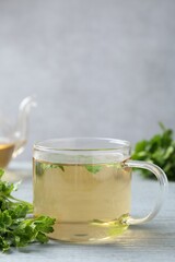 Healthy parsley tea on grey wooden table, space for text. Detox drink