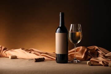 Bottle of wine, wineglass and cloth on brown table, space for text