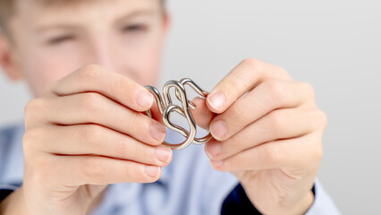 Boy dismantling puzzle with hands at table