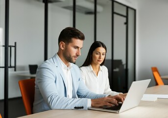 Obraz premium Business colleagues working together on laptop at a modern office space