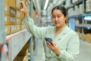 female warehouse manager checks shipping orders on her phone while managing inventory in large storage facility. Female warehouse manager shipping order inventory management