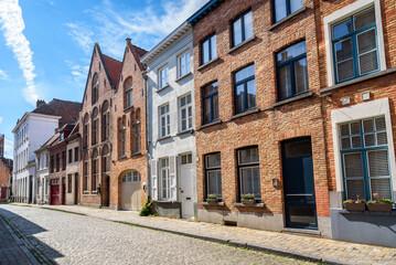 Row of renovated brick town houses along a cobbled street in a old city centre on a sunny summer day