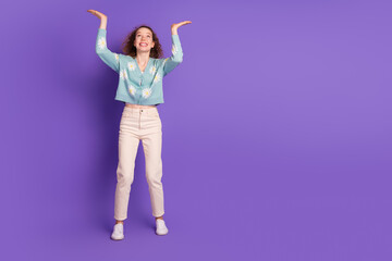 Casual young woman in a floral cardigan smiling and gesturing against a vibrant purple backdrop