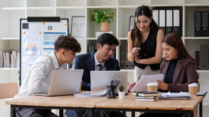 Confident business group reviewing project on laptop in a modern office.