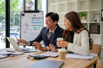 Happy office team discussing data and planning project in modern workplace.