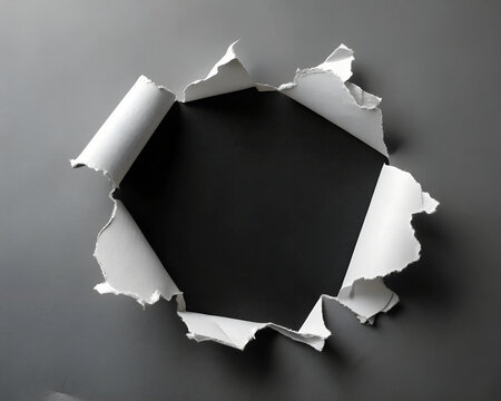 Torn hole in white color and ripped of paper with black background. Torn paper texture with copy space area for text.