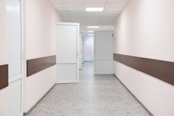 A bright corridor with open white doors. hospital premises.