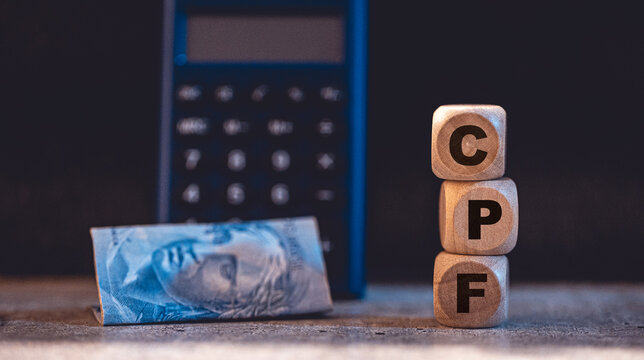 Dinheiro, Brasil, CPF, inadimpl&ecirc;ncia. As inicias CPF em dados de madeira com uma nota de 2 reais e uma calculadora na composi&ccedil;&atilde;o. Foto referente a crise financeira no Brasil e inadimpl&ecirc;ncia. 