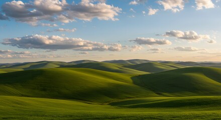 Obraz premium A scenic view of rolling green hills under a blue sky with scattered clouds in the countryside landscape