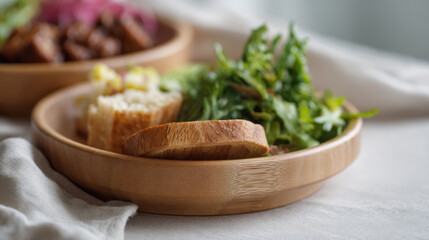 vegan meal with fresh greens and bread on bamboo plate