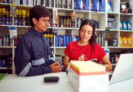 Mechanic receiving instructions from manager at auto parts store