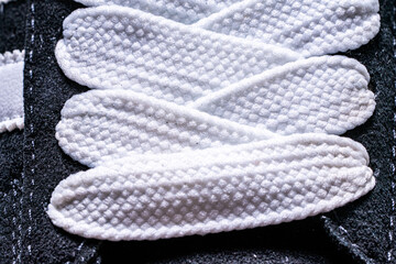 Lace-up on sneakers close-up. White, wide laces in black sneakers.