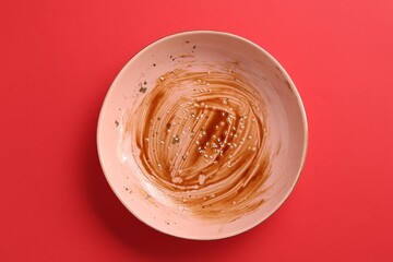 One dirty plate on red background, top view