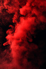 Fototapeta premium Swirling red smoke or mist with suspended particles, creating an ethereal, dynamic, and captivating visual effect against a dark atmospheric background.