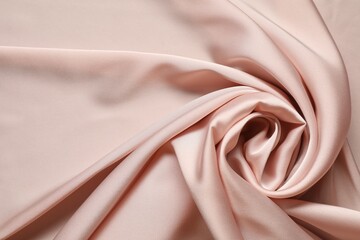 Pink crumpled silk fabric as background, top view