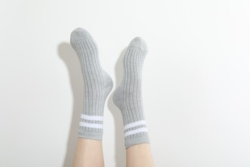 Woman in grey socks on light background, closeup