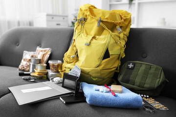 Survival kit. Different emergency supplies on sofa indoors