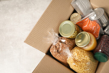Different food products in box on gray table, top view