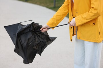 Teenage girl with broken umbrella outdoors, closeup