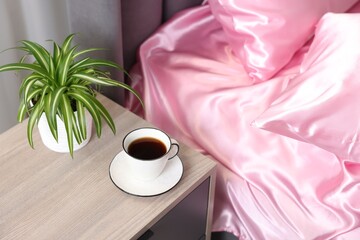 Luxury silk linens on bed and nightstand at home
