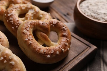 Tasty salted pretzels on wooden board, closeup