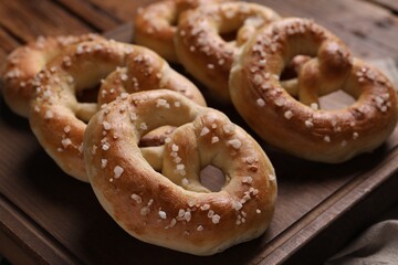 Tasty salted pretzels on wooden table, closeup