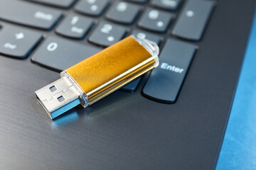 Usb flash drive and laptop on blue table, closeup