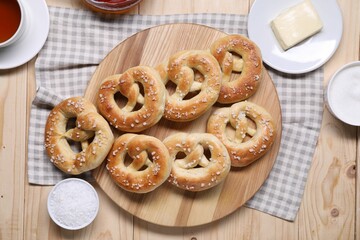 Tasty pretzels, ingredients and tea on wooden table, flat lay
