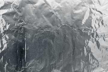 Crumpled silver foil as background, top view