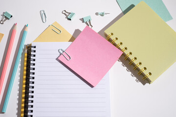 Office or school supplies. Notepad, clips, paper clips and sticky notes, pencils and markers on a colored background.