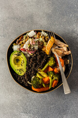 Nutritious, wholesome breakfast featuring quinoa, avocado, roast chicken, and roasted vegetables like sweet potato, zucchini, and broccoli, complemented with a fresh cabbage and radish salad