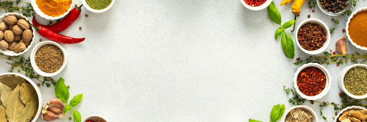 Colorful, fresh herbs and spices framing a gray background, a perfect natural border to bring attention to culinary creativity, top view and copy space, banner