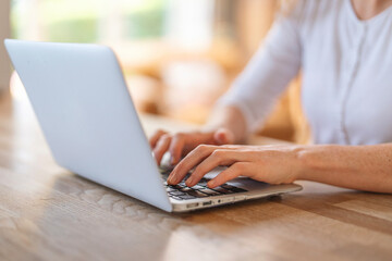 Fototapeta premium Engaging in productive work at a cozy cafe during the afternoon with a laptop and focused attention on tasks